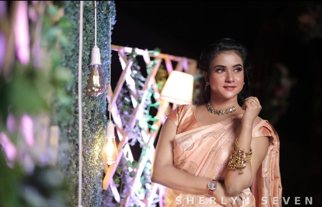 Reception evening look in a peach saree with festive lighting